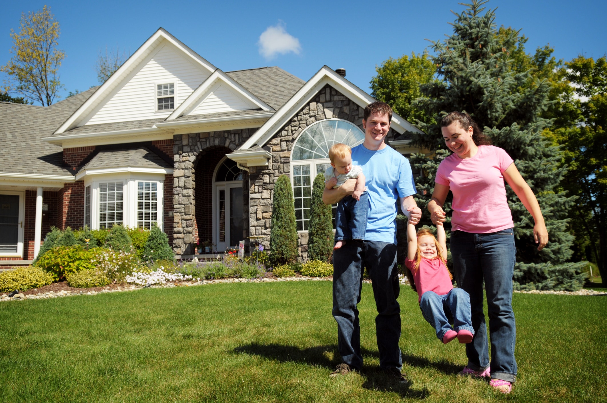 A young family in front of a new home.